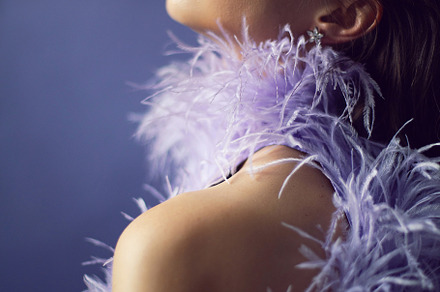 portrait woman in an evening purple dress with feathers stands in the backgroun, a Person Photo by SaulichPhoto
