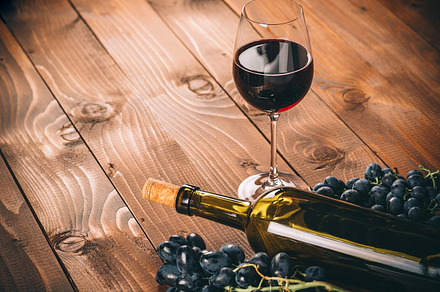 Bottle of white wine, grapBottle and glass of red wine, grape and cork on wooden background e and corks on wooden table