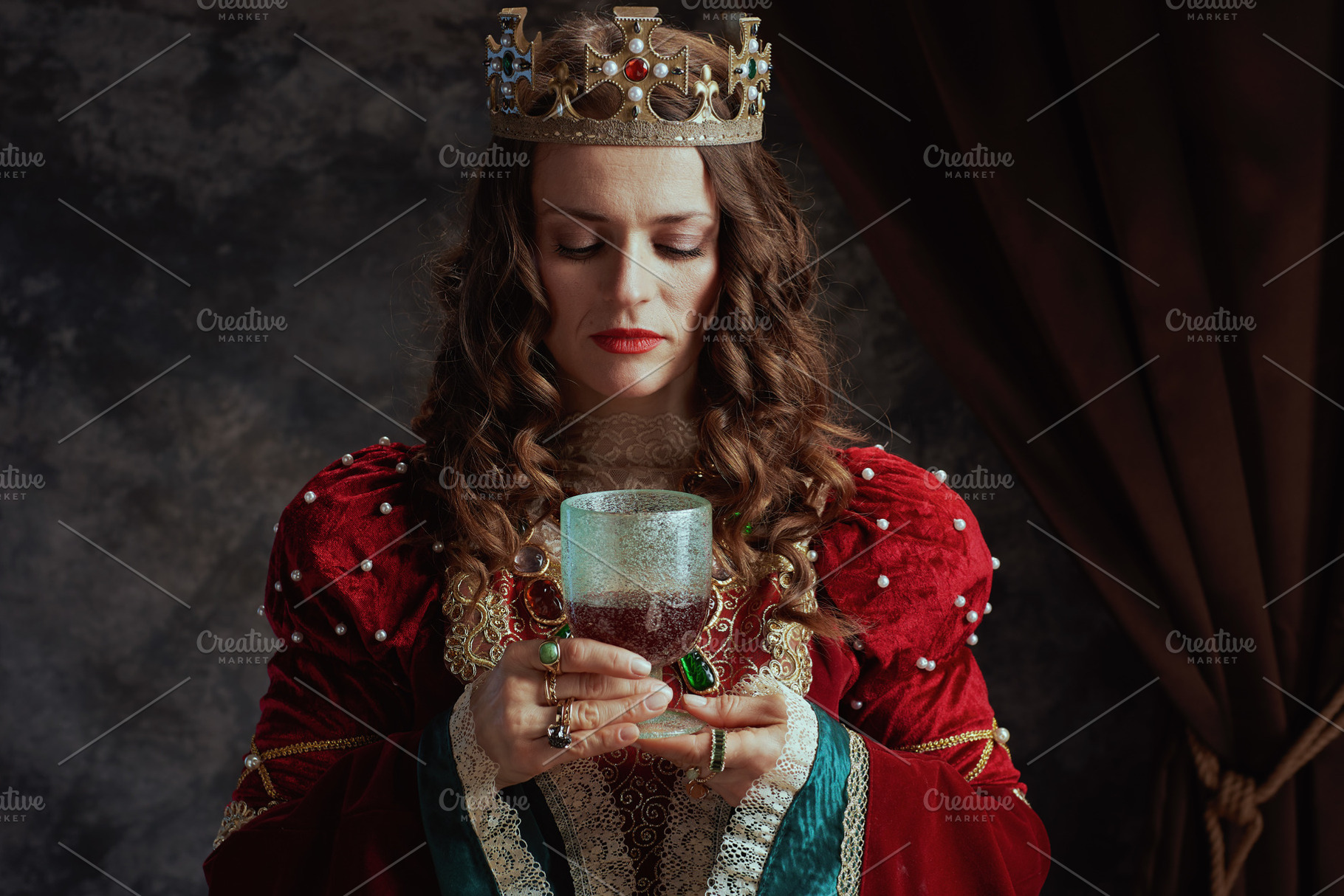 medieval queen in red dress with goblet and crown, a Person Photo by Alliance Images