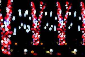Vertical stripes of red and white bokeh lights on black backgrou, a Background Photo by ndanko