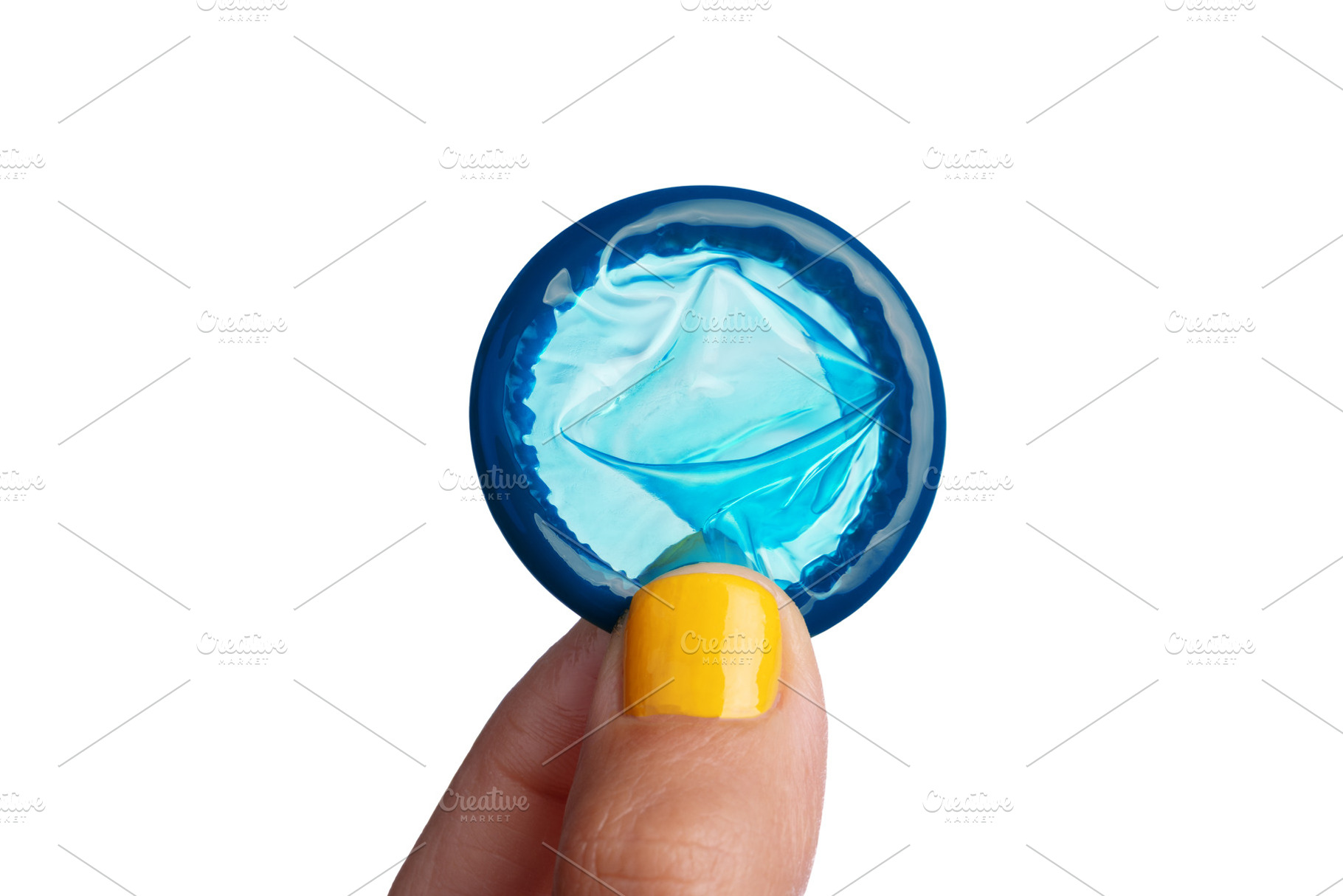 Macro shot of a blue condom held between fingers with yellow nai, a Health & Medical Photo by Ales Munt