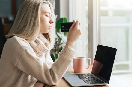 Young woman holding credit card and using laptop computer., a Business Photo by Olena Rudo