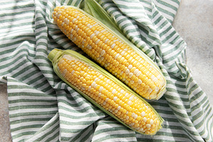 Fresh sweet corn cobs on striped cloth, a Food & Drink Photo by Olena Rudo