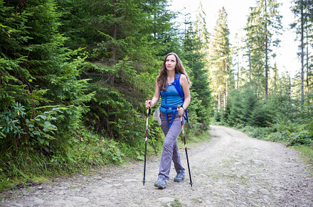 Young woman hiking through the forest in mountains, a Sports & Recreation Photo by serkum