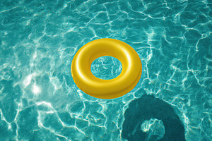 Yellow inflatable ring in pool water, a Photo by Virgo Studio