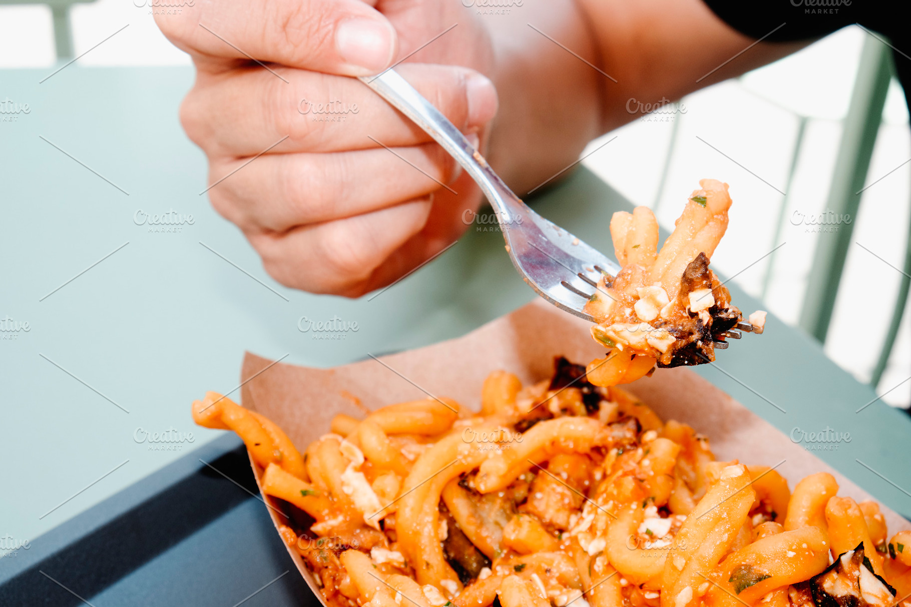 man eating casarecce alla norma outdoors, a Photo by Nito