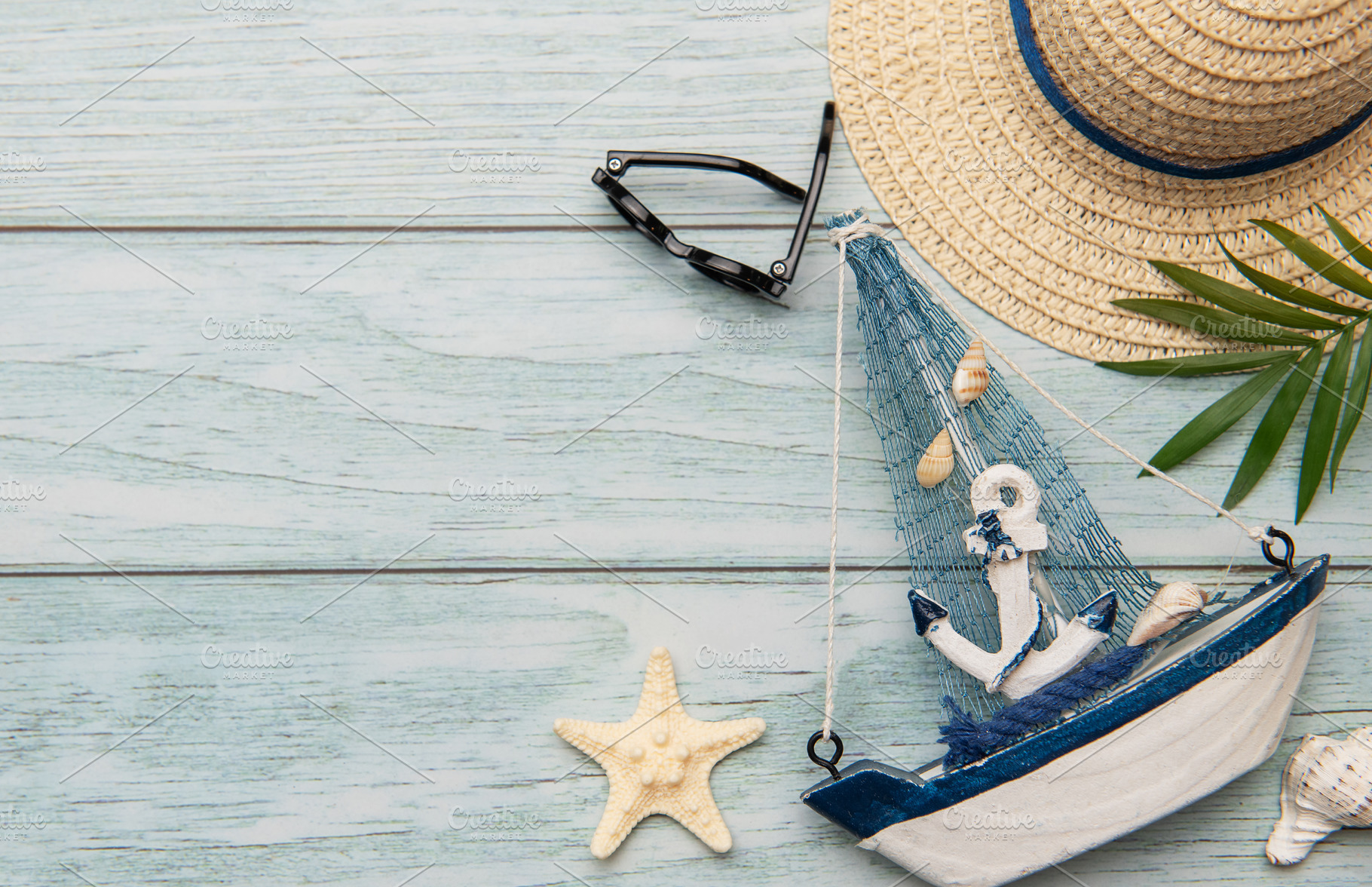 Seashells, sunglasses, straw hat, starfish and decorative sailbo, a Holiday Photo by Olena Rudo