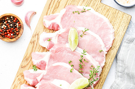 Raw pork chops, meat on cutting board prepared for cooking with, a Food & Drink Photo by 5PH