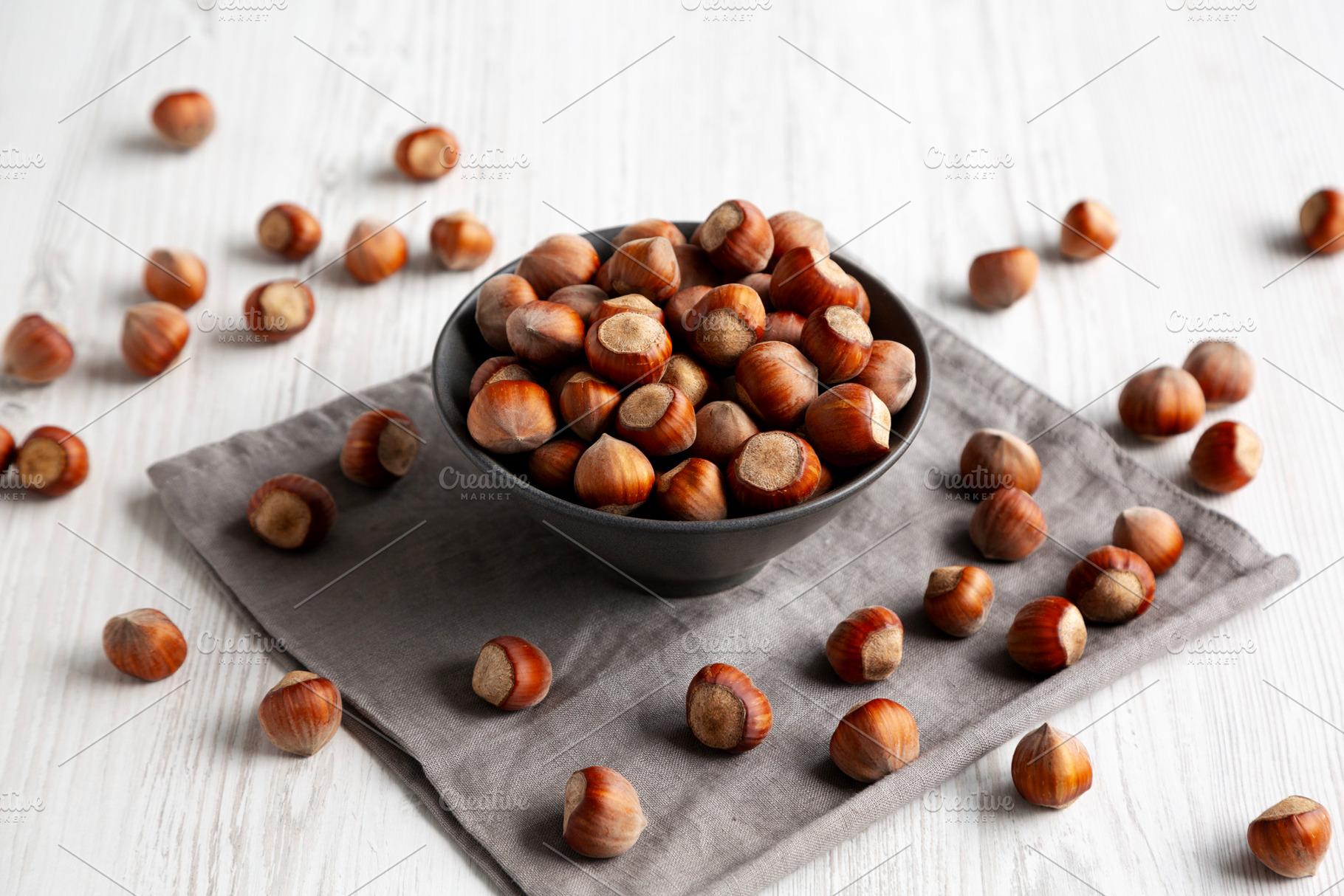 Organic Raw Hazelnuts in a Bowl, side view., a Food & Drink Photo by LiudmylaChuhunova