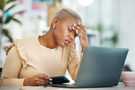 Stress, migraine and African businesswoman in the office while working on project with laptop. Burn out, tired and professional female business employee with a headache in modern corporate workplace., a Photo by Peopleimages.com