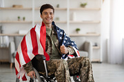 Cheerful military guy in wheelchair with flag of the US, a Photo by Prostock-Studio (Thumbnail 3 of 4)