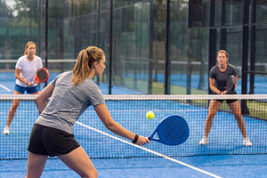 Female padel players in action during match on outdoor court., a Sports & Recreation Photo by Volff