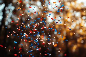 Colorful confetti falls through a su, a Photo by Tanuart