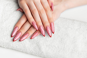 Woman's hands resting on towel with pink stiletto nails, a Beauty & Fashion Photo by Olena Rudo