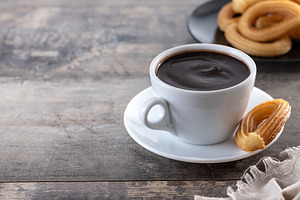 Hot thick chocolate in a white cup with churros, a Food & Drink Photo by etorres69