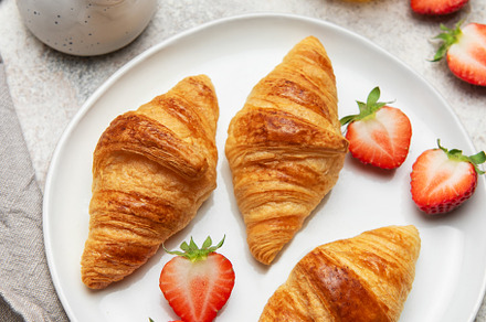 Delicious french breakfast with croissants, strawberries, honey, a Food & Drink Photo by Olena Rudo