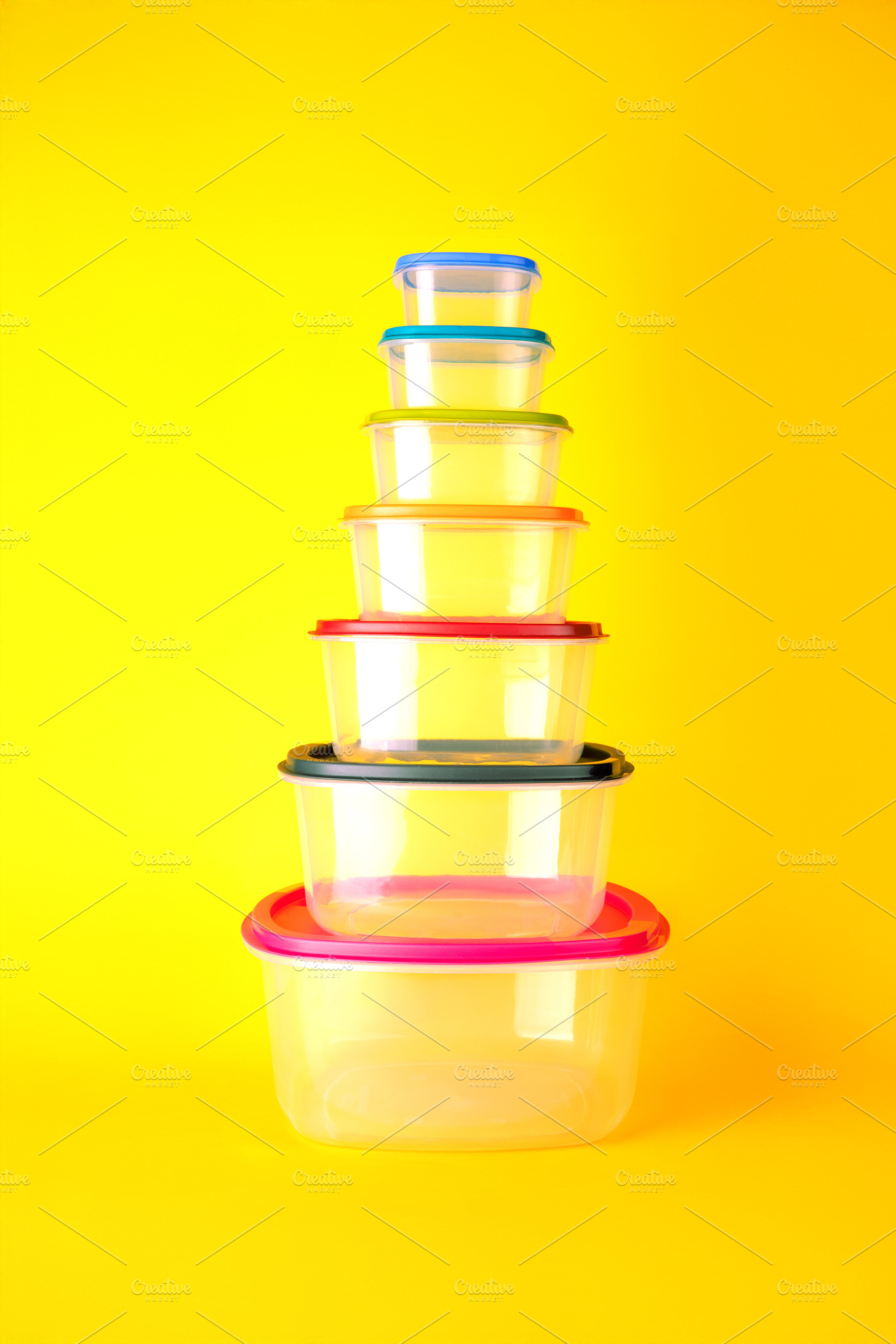 Transparent plastic containers with colorful lids stacked in a p, a Background Photo by Ales Munt