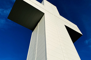 Modern white Bald Knob Cross of Peace shaped monument towering against a blue s, a Photo by AS photostudio