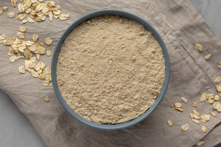Organic White Oat Flour in a Bowl on a gray background, top view, a Food & Drink Photo by LiudmylaChuhunova