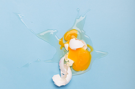 Broken white egg and spray on the, a Food & Drink Photo by zakiroff