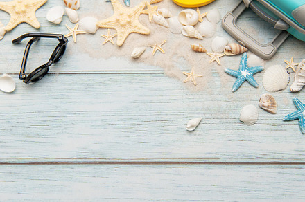 Summer accessories creating a frame on light blue wooden backgro