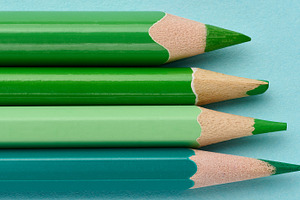 Row of green wooden pencils on a blue background, a School & Education Photo by ndanko