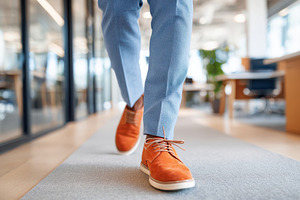 Walking in stylish orange shoes in a modern office, a Business Photo by AlyaAnd