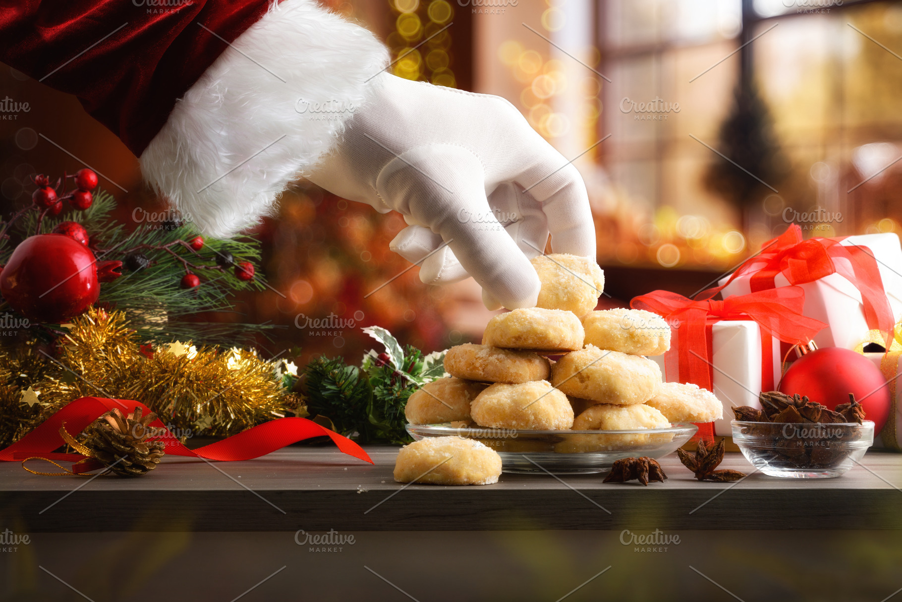 Santa's hand taking cookie on table with Christmas decorations, a Food & Drink Photo by Davizro's Market