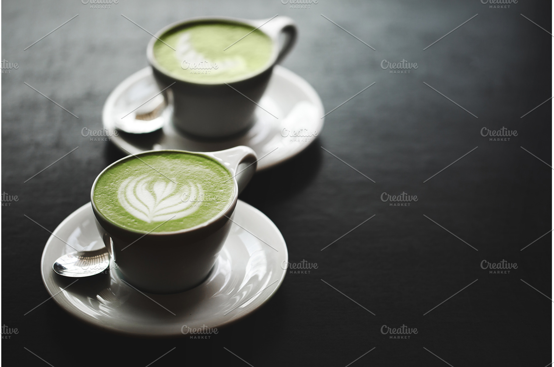 Two cups of matcha latte on black, a Food & Drink Photo by Anna Efetova