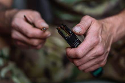 Close-up shot of hands of Ukrainian military man loads the assault rifle magazi