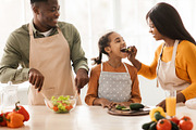 Cheerful Black Family Preparing Dinner Making Fresh Salad In Kitchen, a Photo by Prostock-Studio (Thumbnail 2 of 2)
