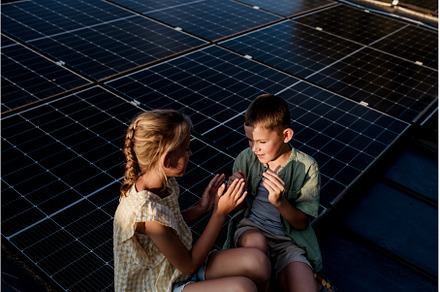 Two young siblings sitting on roof