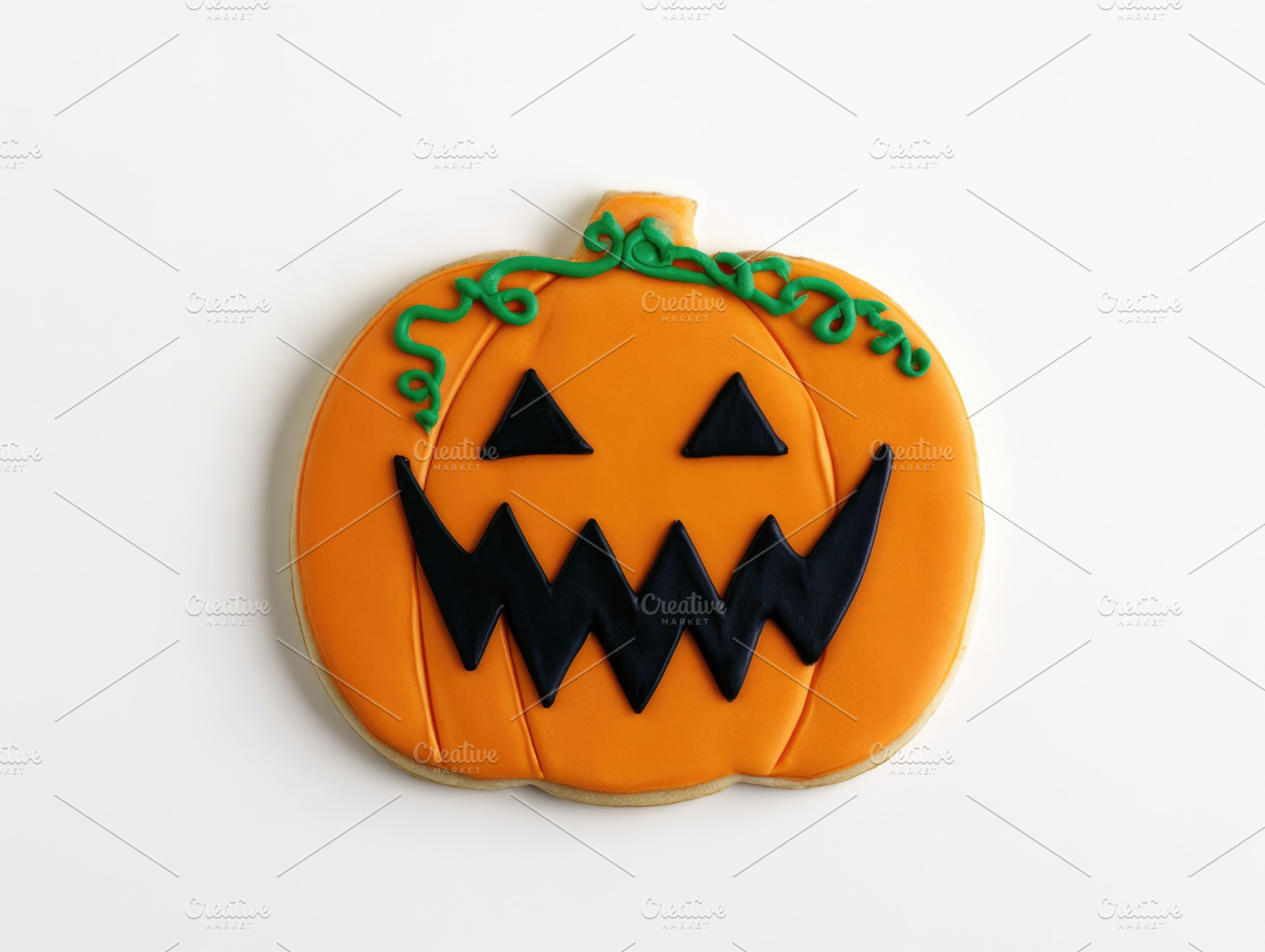 Halloween pumpkin cookie with jack o lantern face isolated on wh, a Food & Drink Photo by José Manuel Gelpi
