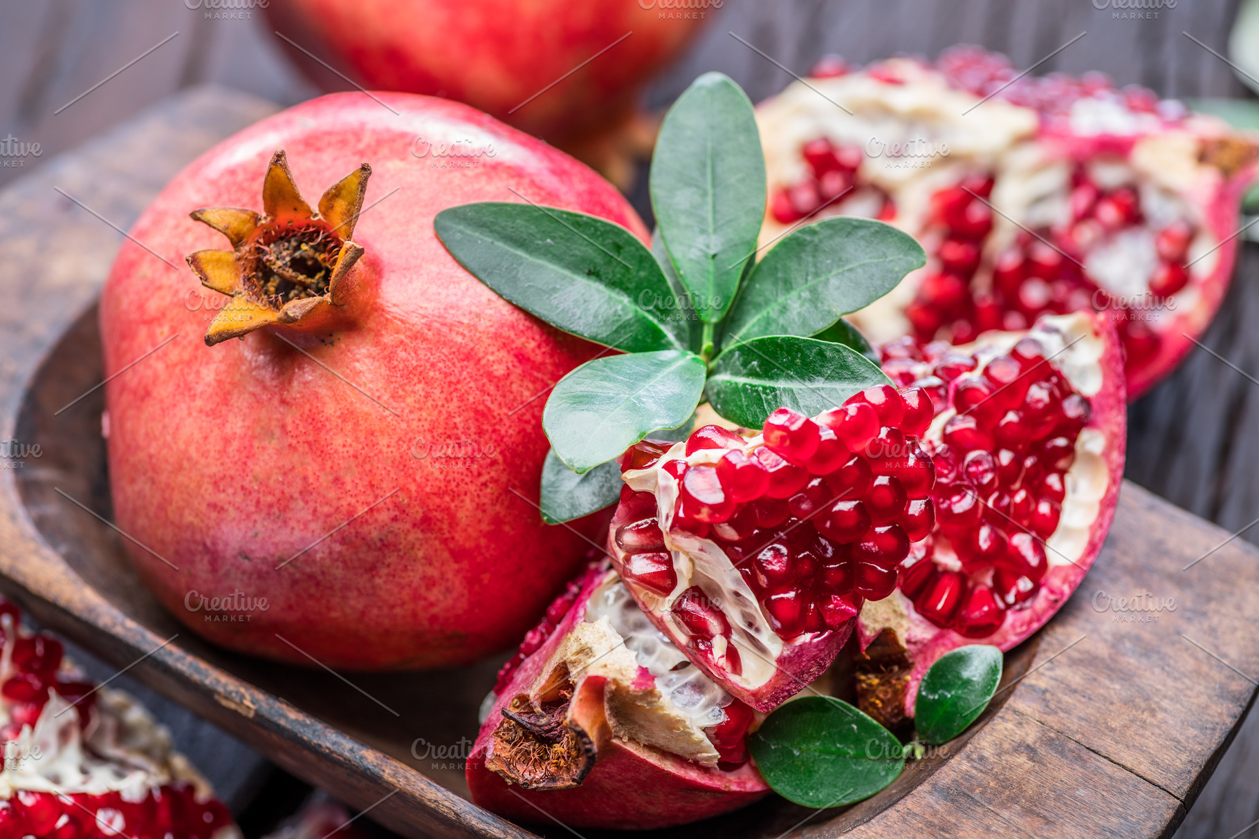 Ripe pomegranate fruits on the wooden background., a Food & Drink Photo by Volff