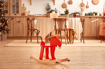 Rocking red horse in festive Christmas kitchen room, a Holiday Photo by its_al_dente
