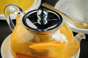 Fruit tea with mango and mint in a glass teapot on the table, a Food & Drink Photo by Budarinphoto
