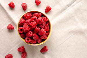 Organic Raw Red Raspberries in a Bowl, top view. Copy space., a Food & Drink Photo by LiudmylaChuhunova
