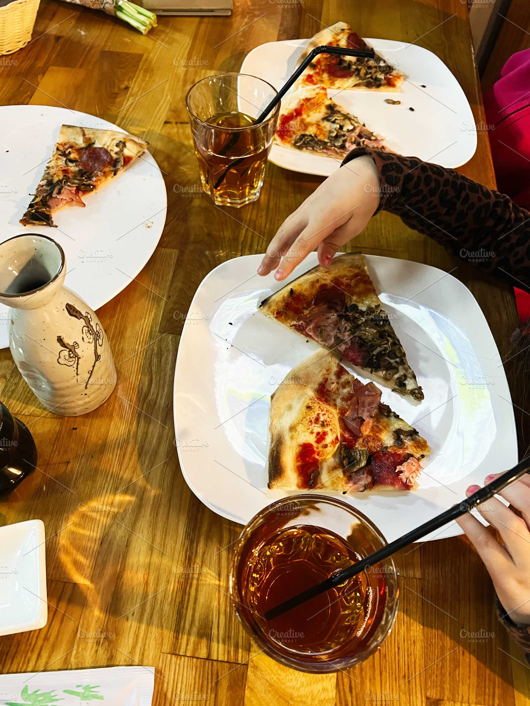 Family enjoying a meal with pizza and refreshing drinks on wooden table, a Photo by AS photostudio