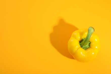 Yellow bell pepper on yellow background, space for text, a Food & Drink Photo by AtlasStudio PRO