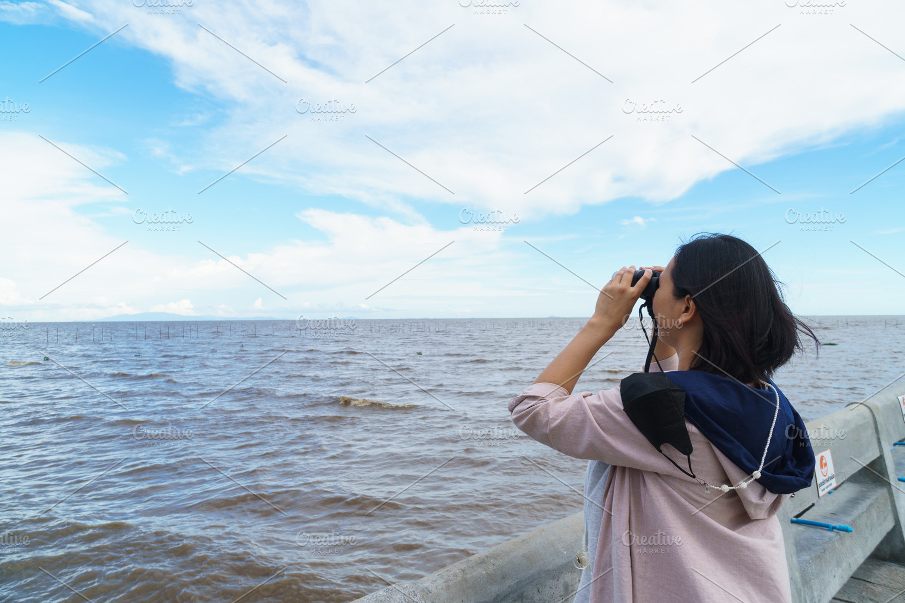 Exploring ocean view with binoculars, woman enjoys nature beauty, a Person Photo by a454
