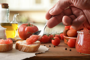 Hand Spreading Tomato Topping on Rustic Toast, a Food & Drink Photo by Davizro's Market