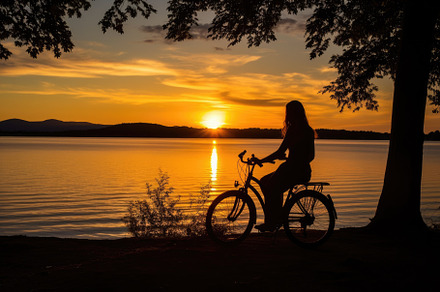 A low angle, her silhouette framed against the sunset, mountain, a Sports & Recreation Photo by designvectx