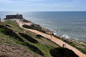 Cliffside walkway near a lighthouse overlooking the ocean in Nazare, Portugal, a Photo by AS photostudio