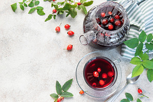 Rosehip tea brewing in glass teapot and cup with fresh rose hips, a Food & Drink Photo by Olena Rudo