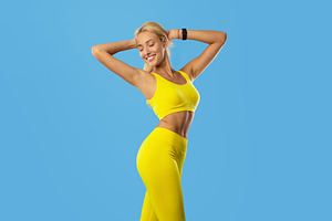 Smiling Sporty Woman Posing Isolated On Blue Background, a Photo by Prostock-Studio