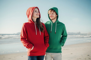 Man & woman in red and green hoodies, a Photo by Pavel_design