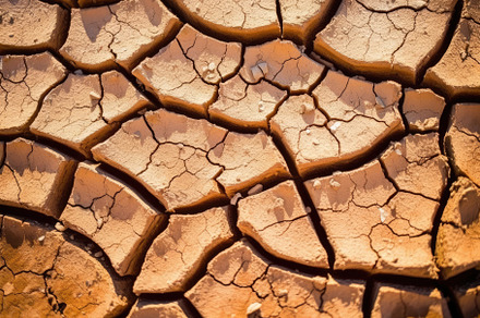 Dry cracked land in a desert, in the style of terracotta, enviro, a Nature Photo by designvectx