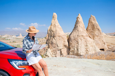 Woman road tripping and looking at the map. Travel by car, a Person Photo by travnikovstudio
