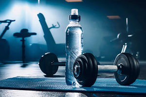 Barbell and drink on blue mat in gym blue backlit, a Sports & Recreation Photo by Davizro's Market