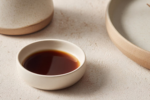 Bowl with dark liquid on a table, a Photo by Beautiful things
